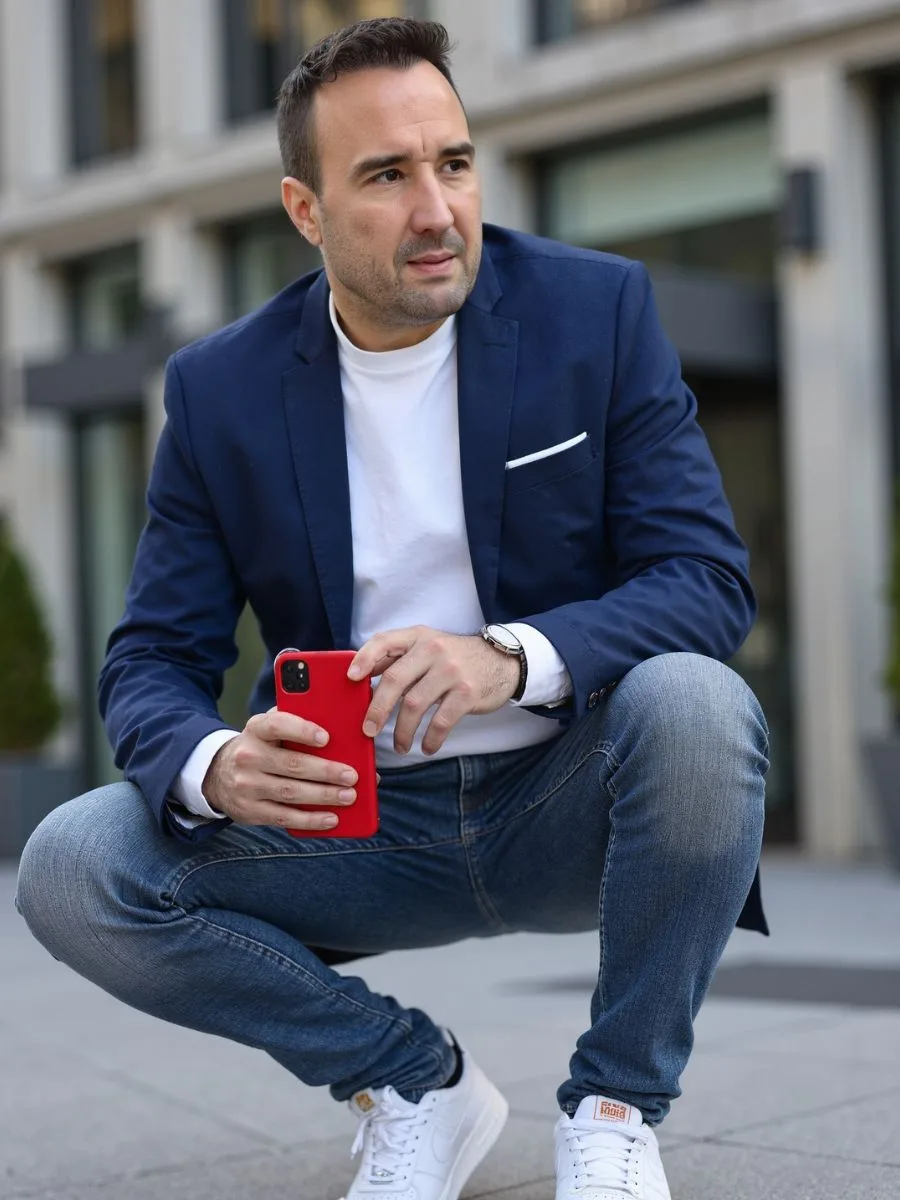 Christian Gottschling mit Smartphone vor einem Wohnhaus