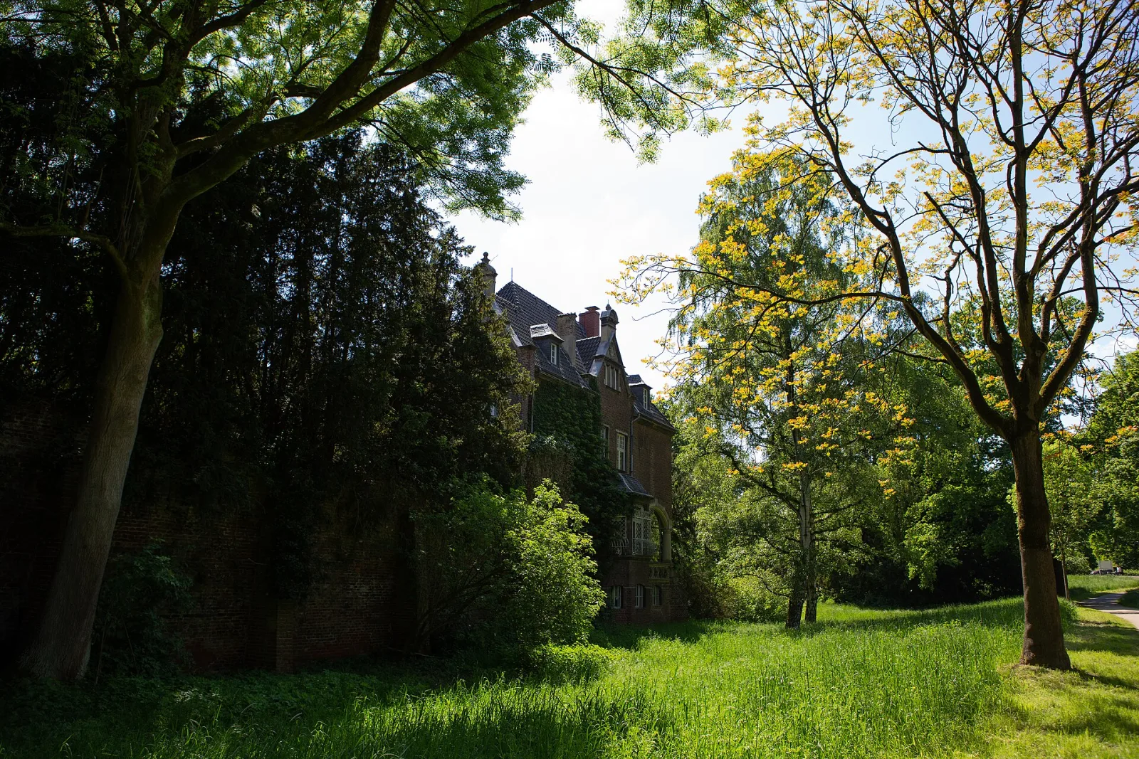 Schloss Elbroich hinter Bäumen im Elbroichpark – Düsseldorf-Holthausen